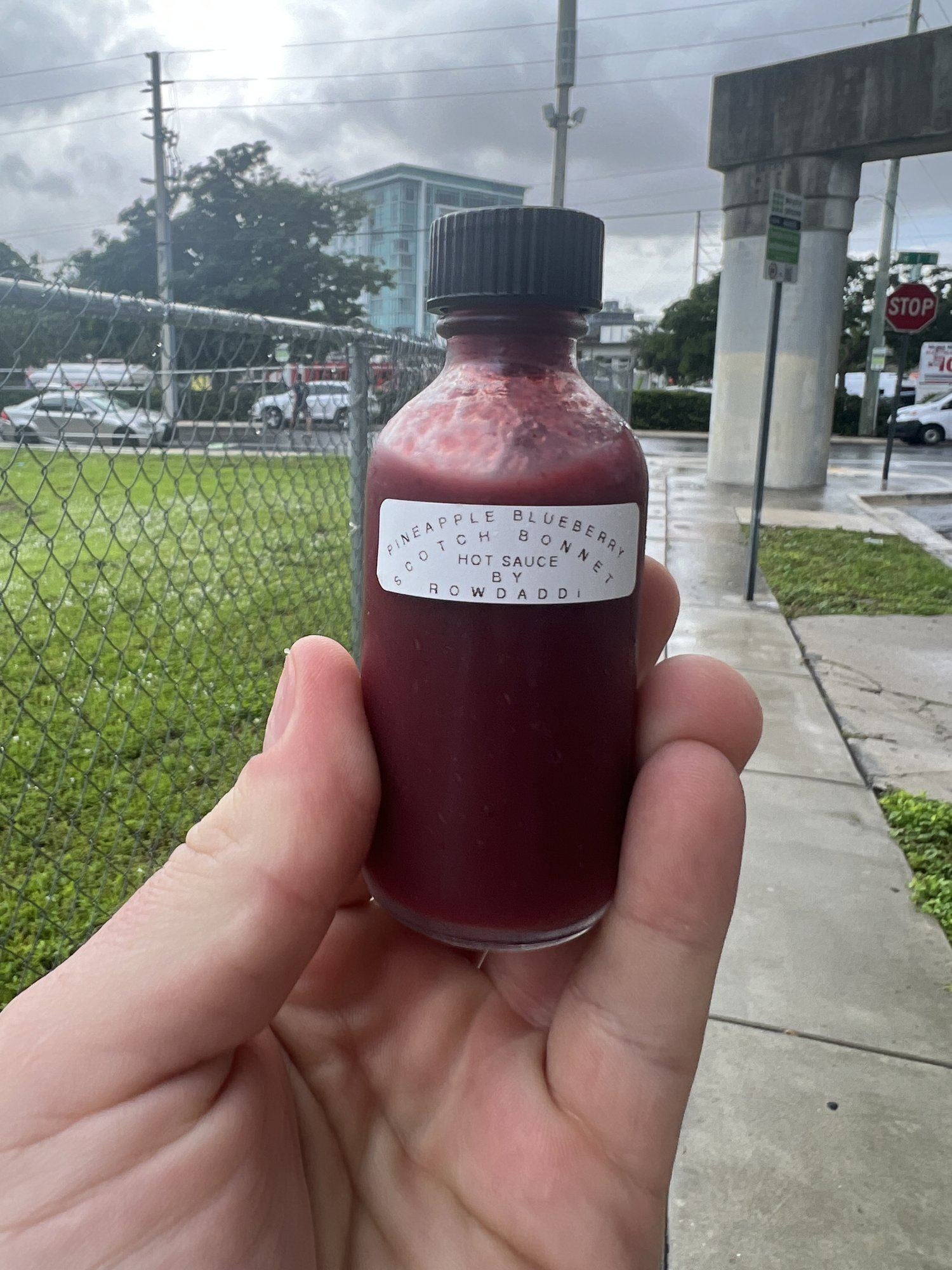 The original VIOLET prototype bottle, Miami 2023, with a typed label reading pineapple blueberry scotch bonnet hot sauce